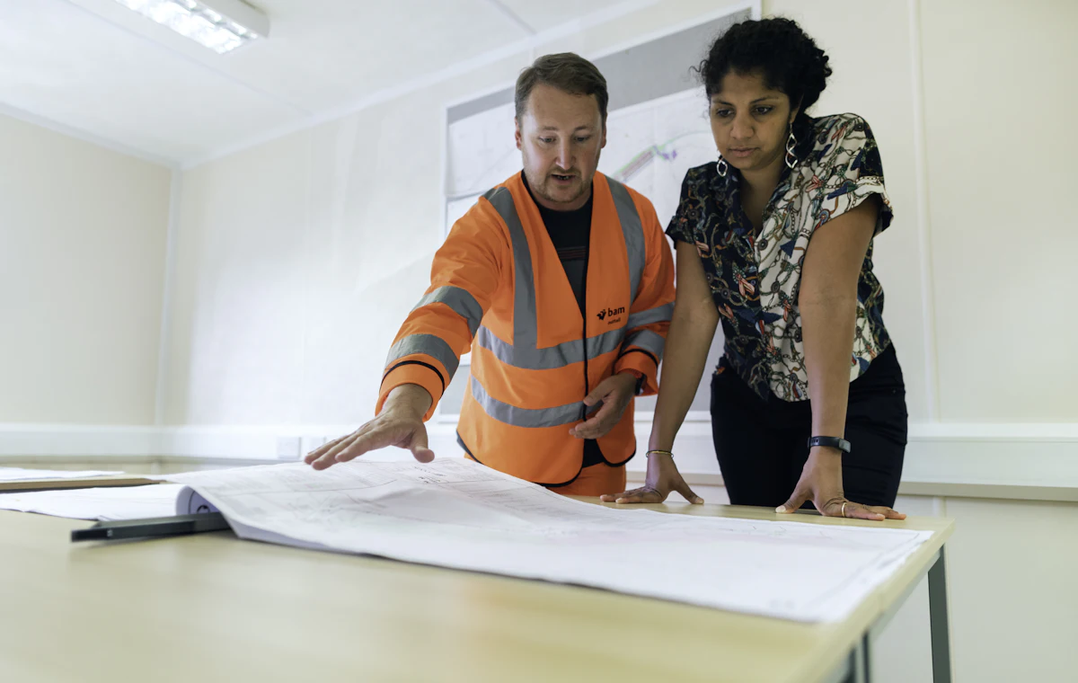 Two engineers reviewing drawings at a desk